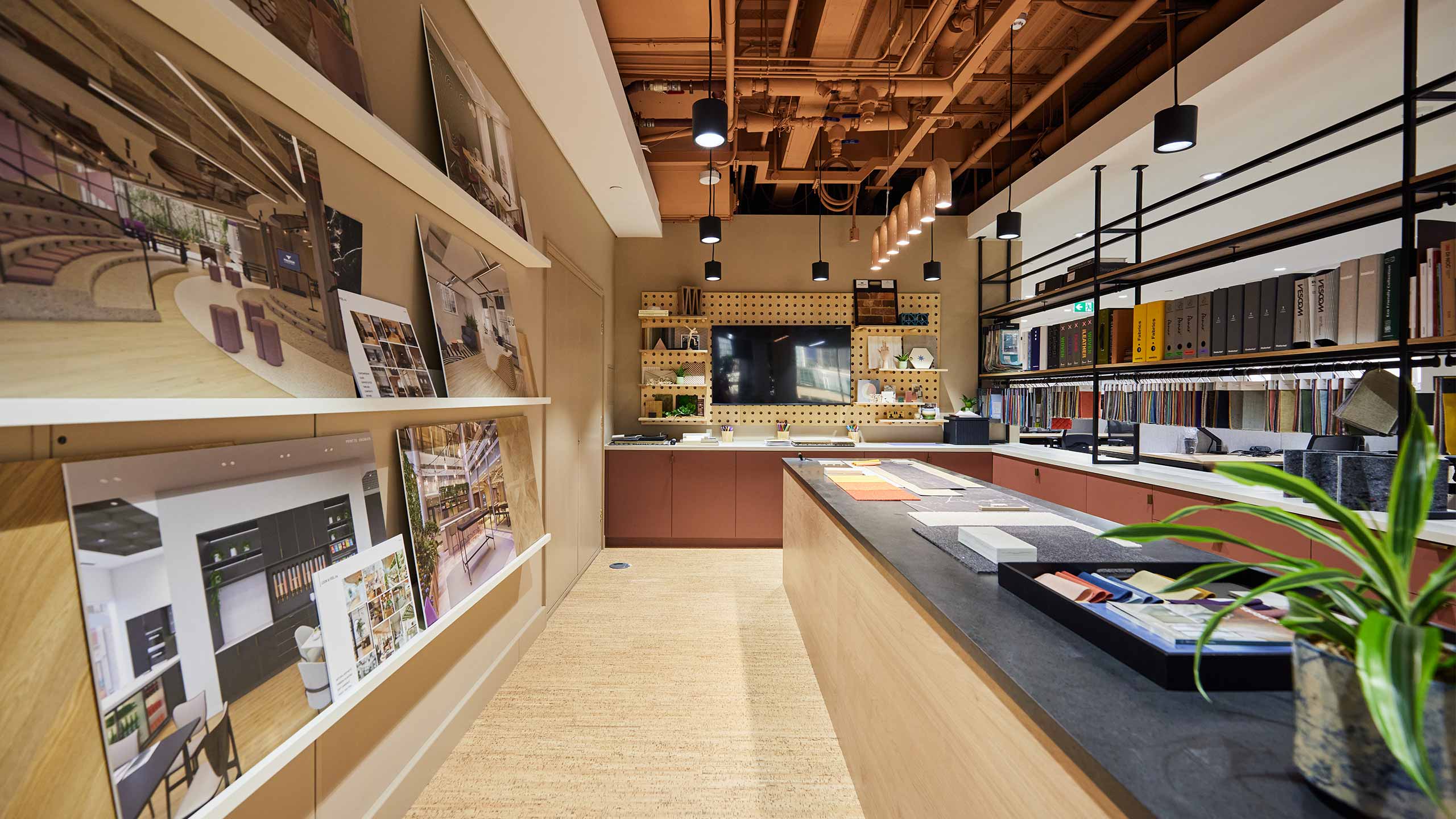 Materials library with interior design samples, shelving, and workspace island at 24 Chiswell Street by ODCreate.